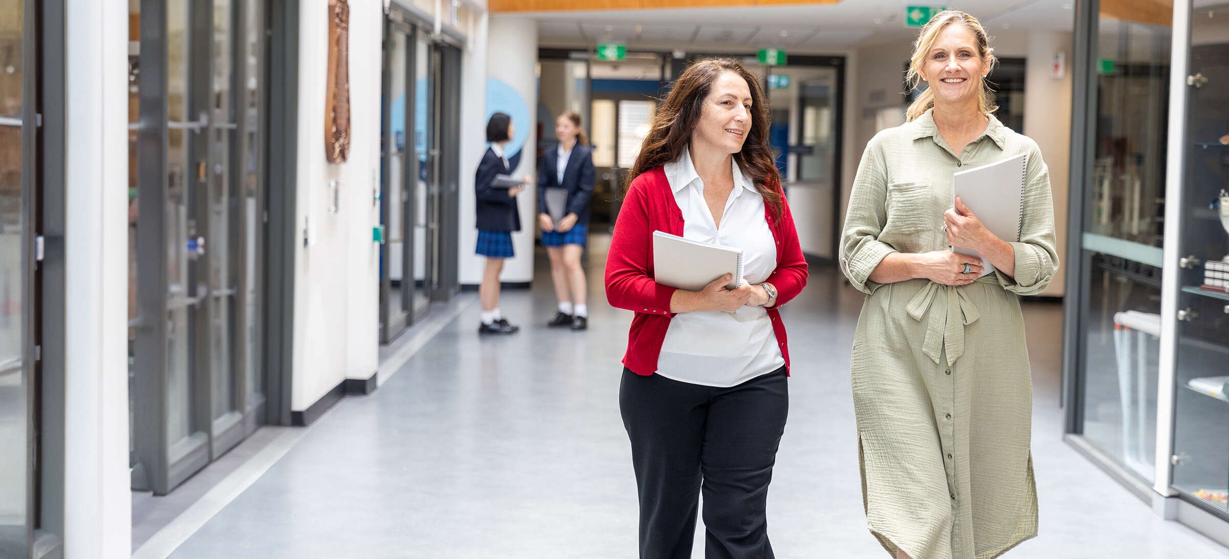 Two school staff members walking together through a school